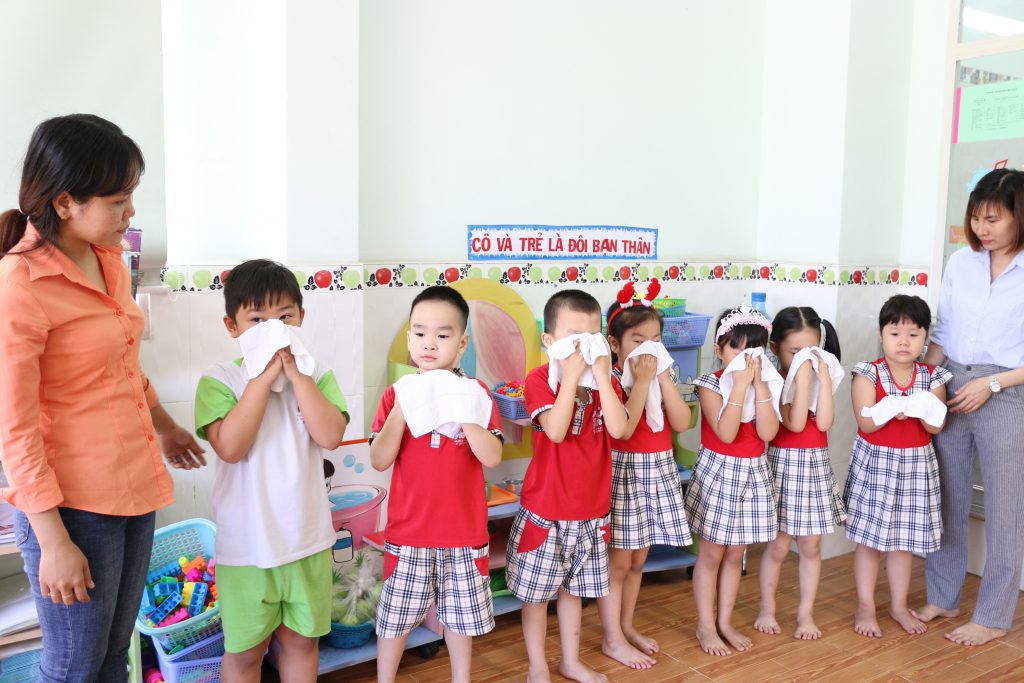 các bé dùng khăn lau mặt tại trường